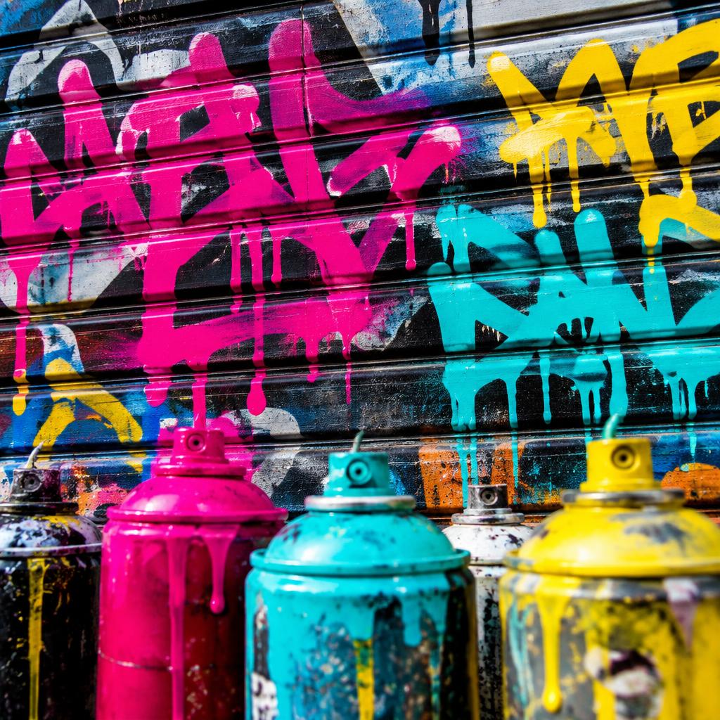 Bombes de peinture devant un mur de graffiti coloré